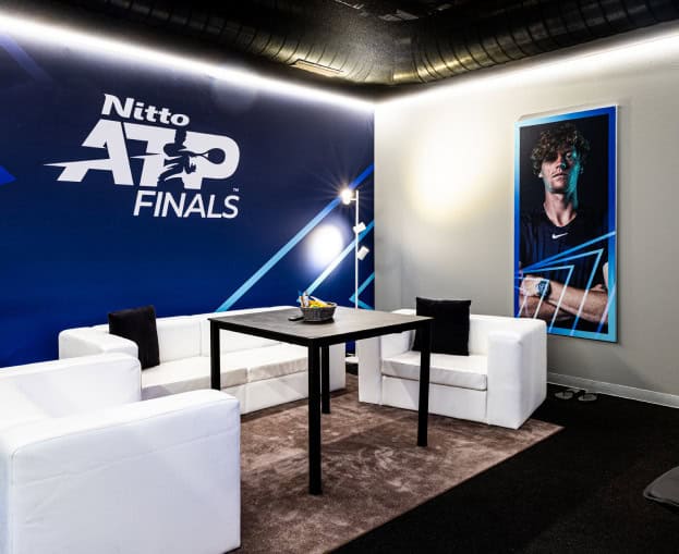Nitto ATP Finals event lounge with seating and promotional poster.