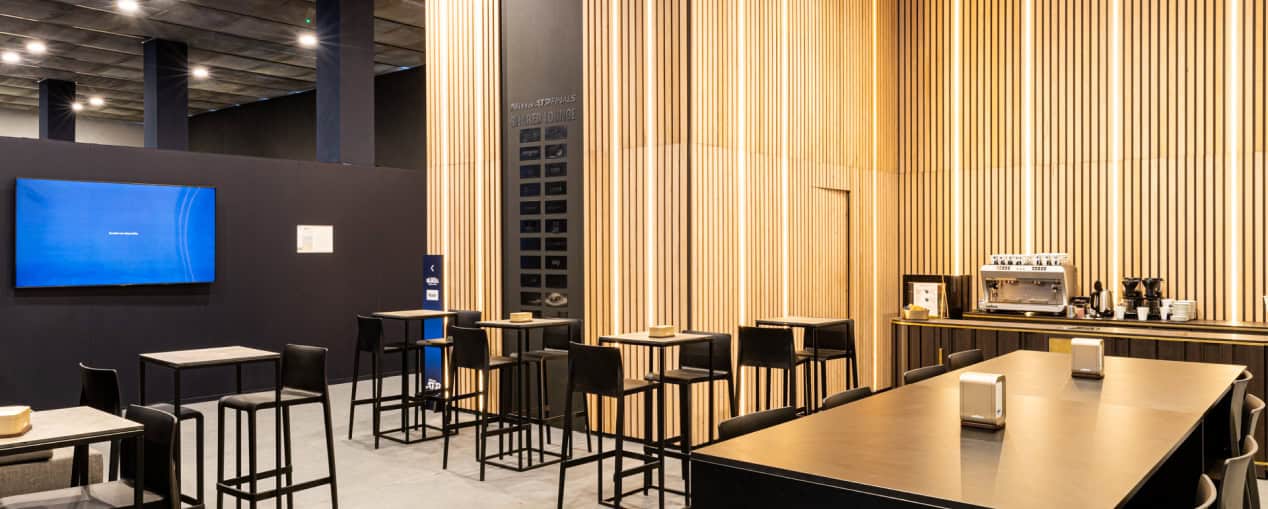 Modern event space with seating and a large screen for presentations.