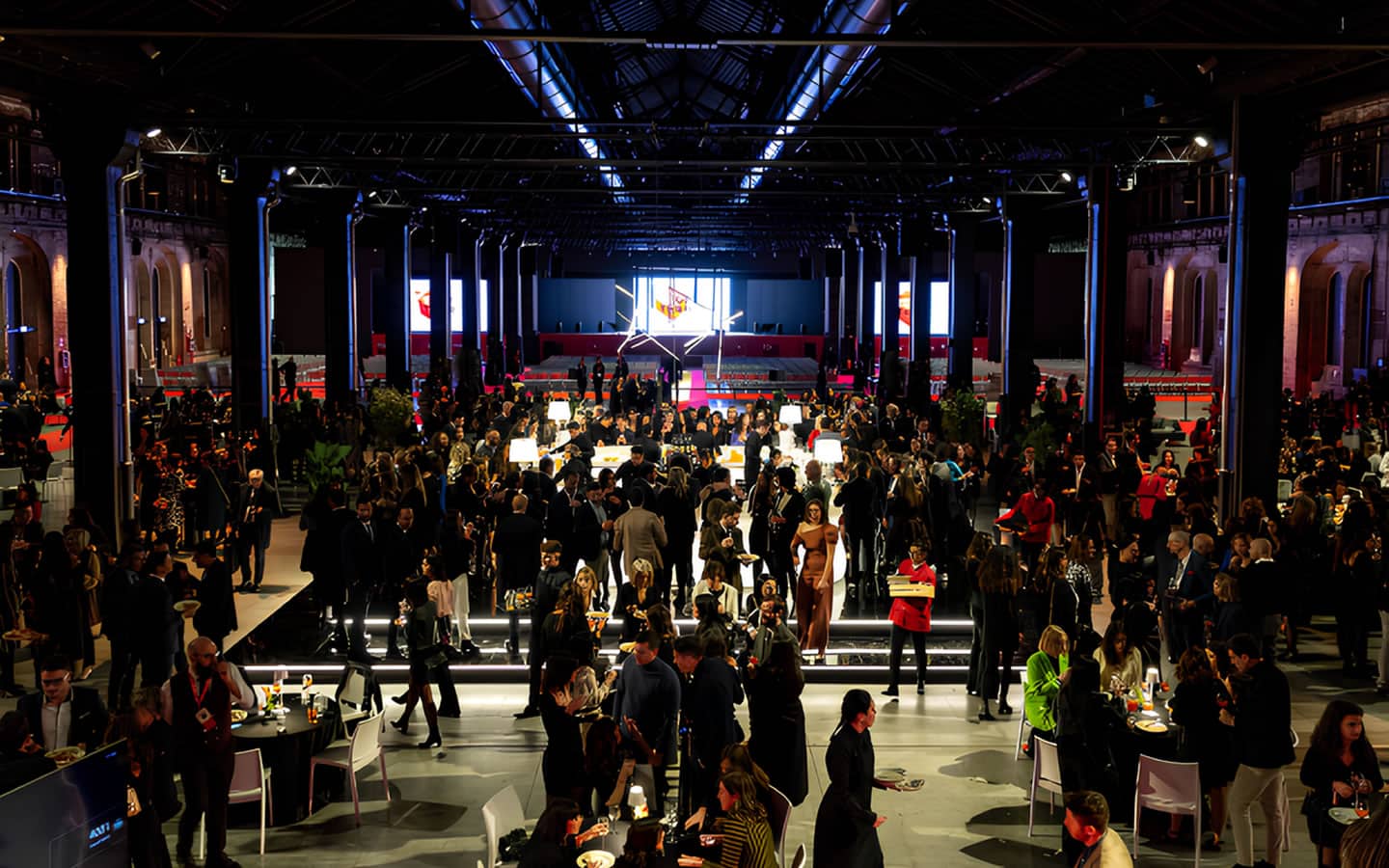 Crowd at a large indoor event with stage and lighting at Synergie OGR.