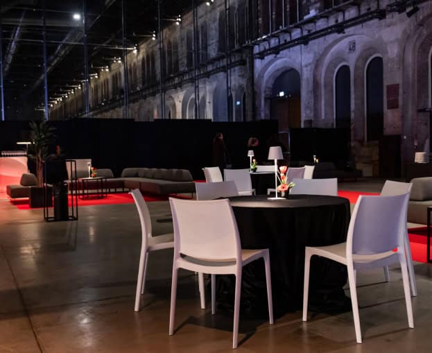 Spazio evento elegante con tavoli e sedie in un ambiente industriale.