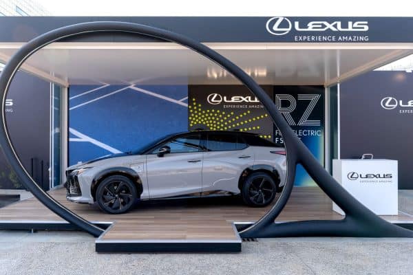 Auto Lexus in esposizione con struttura moderna e logo Lexus in background.