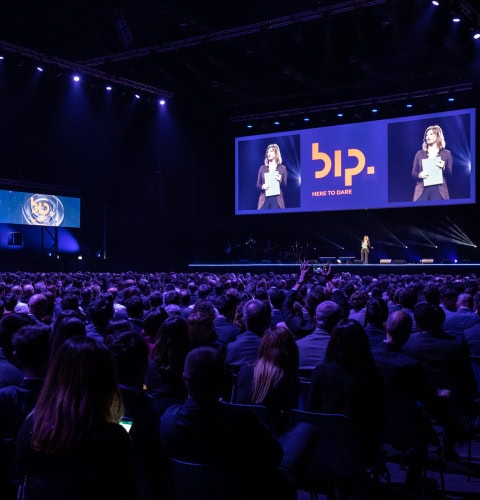 Evento BIP con pubblico numeroso e presentatrice sul palco.